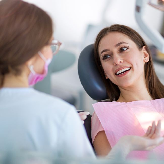 Woman in dental chair smiling at dentist